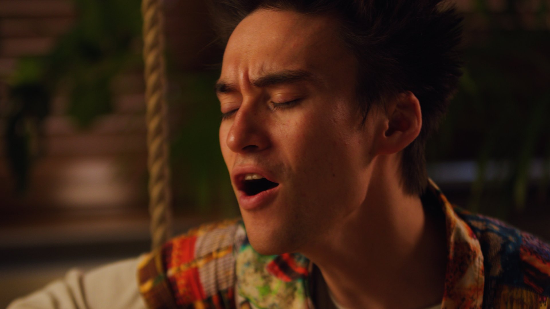 Close up of a man's profile with his eyes closed as he sings.