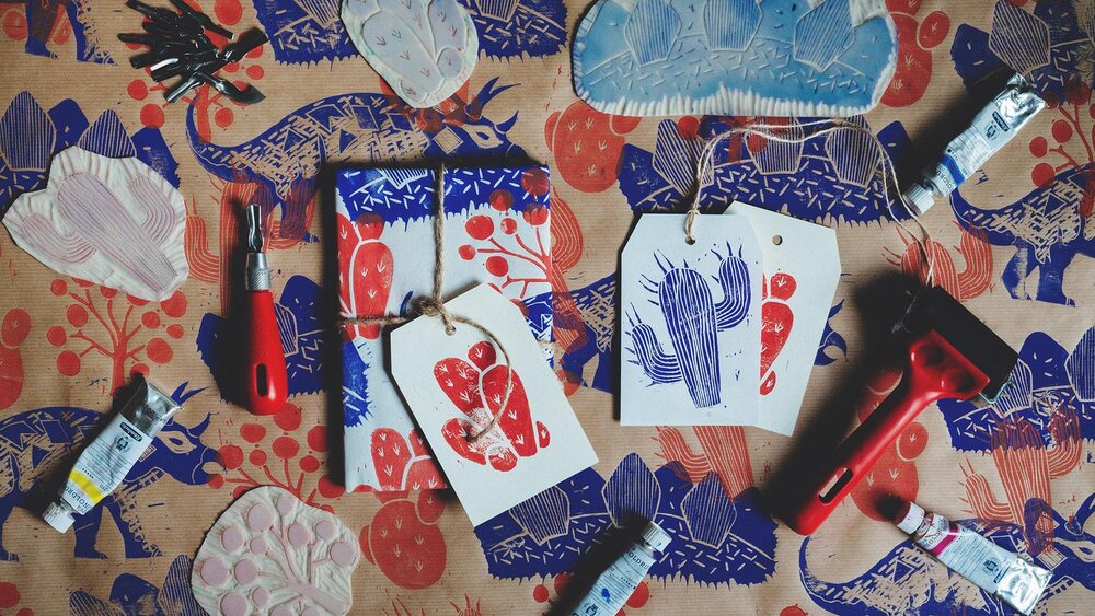 Pictured: Dinosaur Linocut Wrapping Paper & Gift Tags by Evgeniya & Dominic Righini-Brand from their Skillshare course, Printmaking at Home: Creating Linocut Wrapping Paper & Gift Tags .