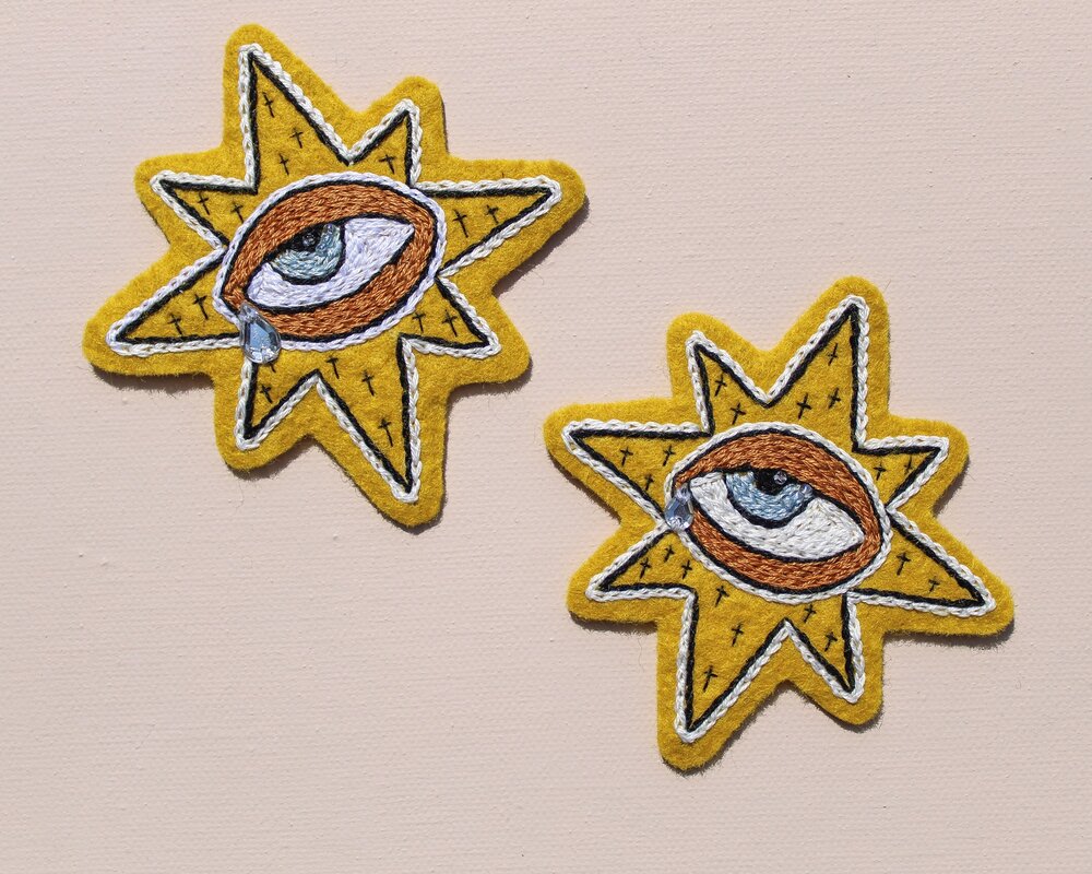 "Weepy Starry Eye" hand embroidered patches by Carly Owens