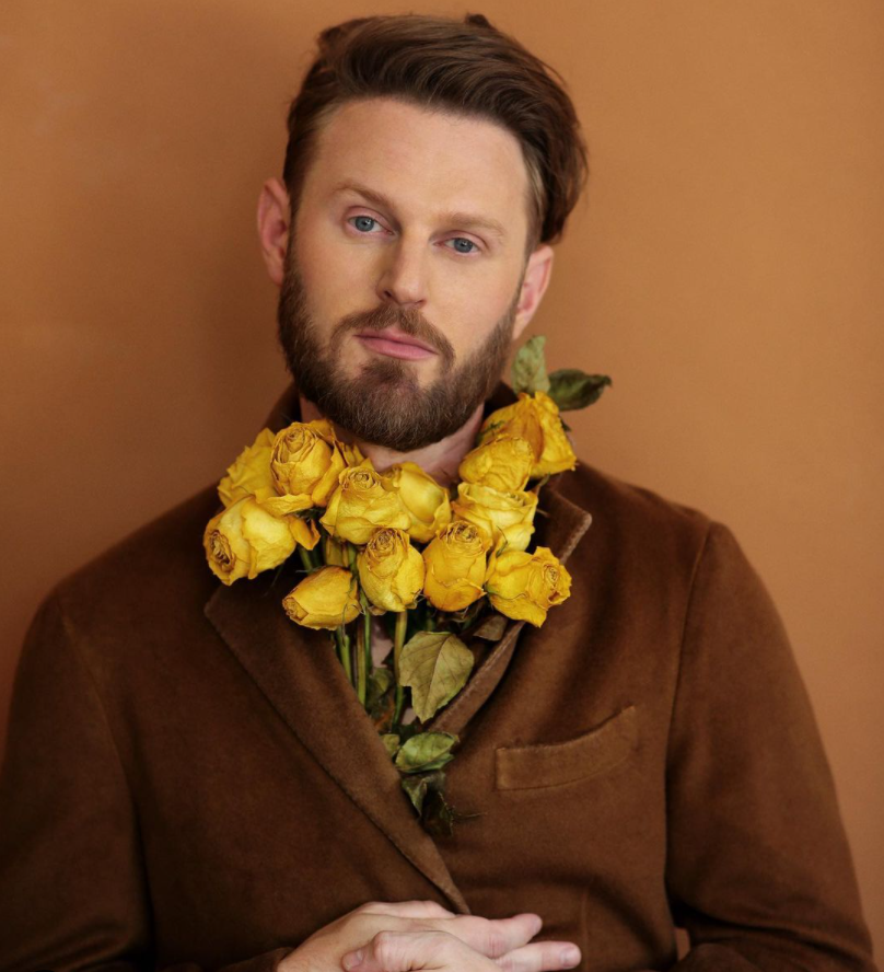 Image via Instagram @bobby Bobby Berk poses with a bouquet of yellow roses.