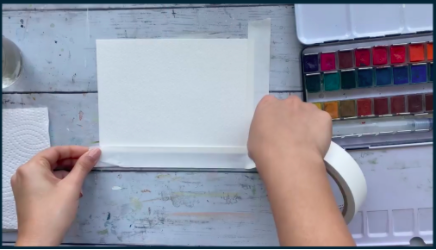 Skillshare instructor Alifya Tarwala secures her watercolor paper before beginning her landscape painting.
