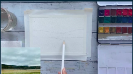 This watercolor illustration will be an outdoor landscape scene. Here, the artist sketches out the general shape of the trees, mountains, and pond she will be painting.