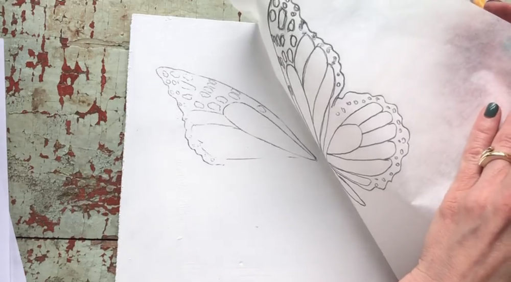 Transfer the first side of the butterfly onto a clean surface by placing the tracing paper face down and tracing again.