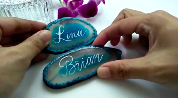 In the course Adding Modern Calligraphy and Brush Lettering On Quartz , Skillshare instructor Joy Tay explains how to incorporate hand lettering on materials such as agate and rose quartz—which you can further customize into a keychain.
