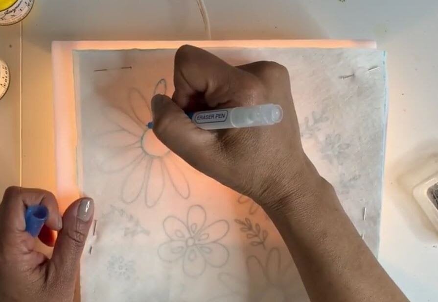 Rekha Krishnamurthi, instrutora da Skillshare, trabalhando em uma superfície iluminada.
