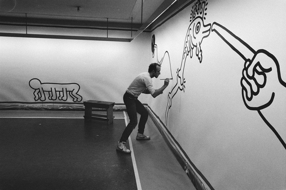 Artist Keith Harring at work on a modern line drawing in 1986 ( image source )