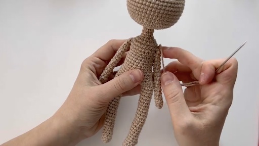 Hands holding amiguri doll almost done.