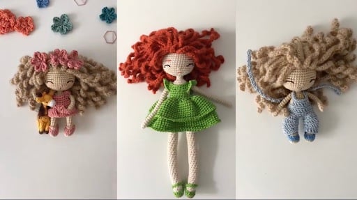 3 amiguri girl dolls: small amiguri doll with light brown curly hair and pink dress, amiguri doll with red curly hair and green dress, small amiguri doll with light brown curly hair and blue overalls.