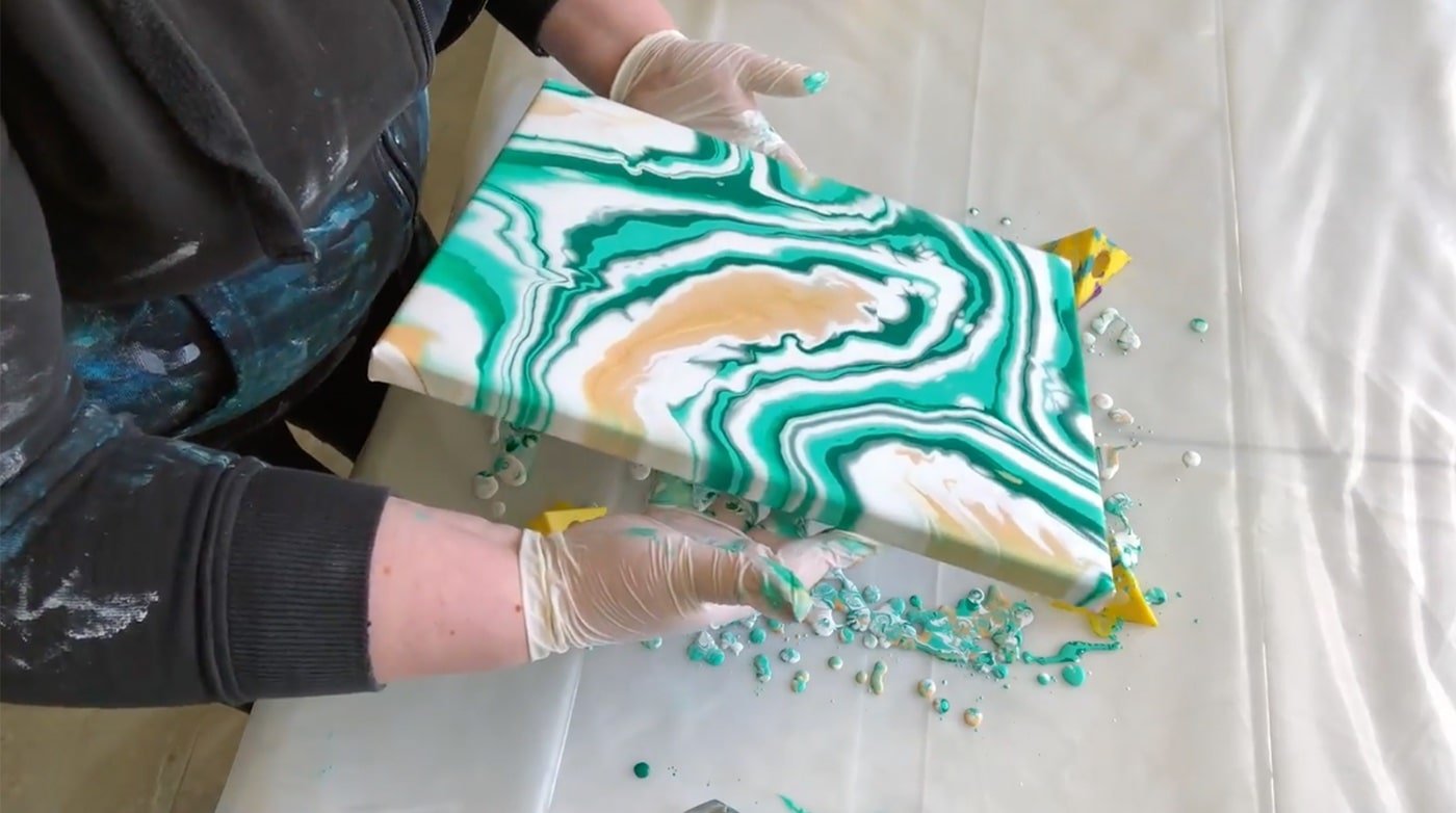 Tilting the canvas to move the paint around. 