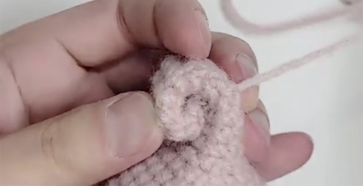 Pink crochet amigurumi tail.
