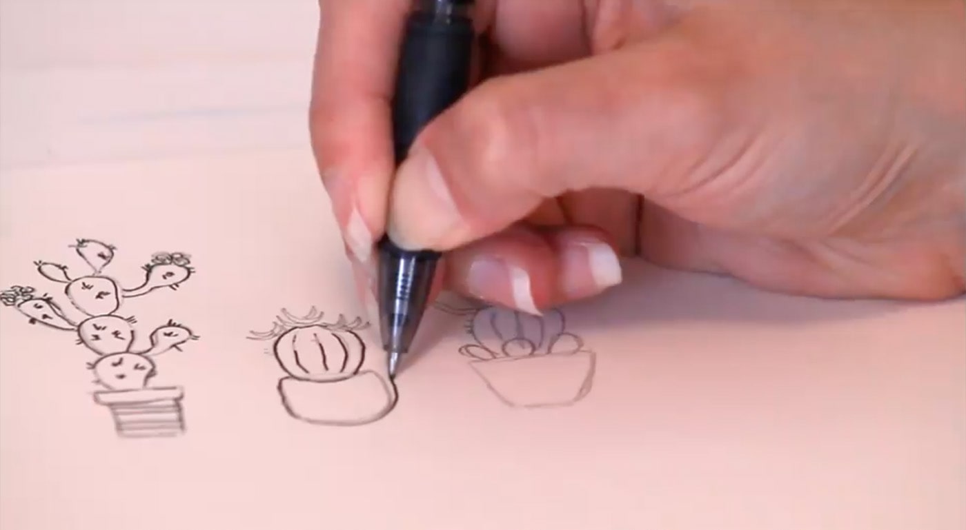 Hand drawn doodle of three cactuses with a black pen.