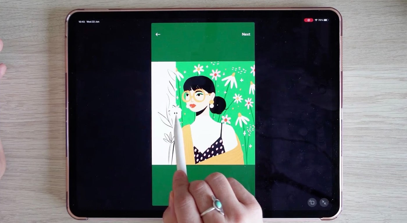An overhead shot of teacher Charly Clements working on her iPad. On screen, there’s a drawing of a woman with glasses and dark hair in front of a green background, and Charly is dragging her Apple Pencil across the drawing, leaving the linework but removing the color. 