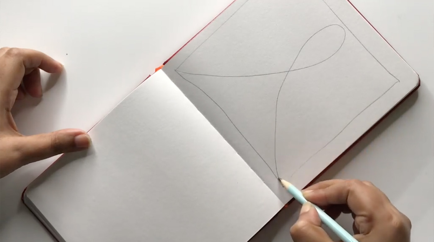 A square with a loop in the center is drawn in a notebook with a pencil. 