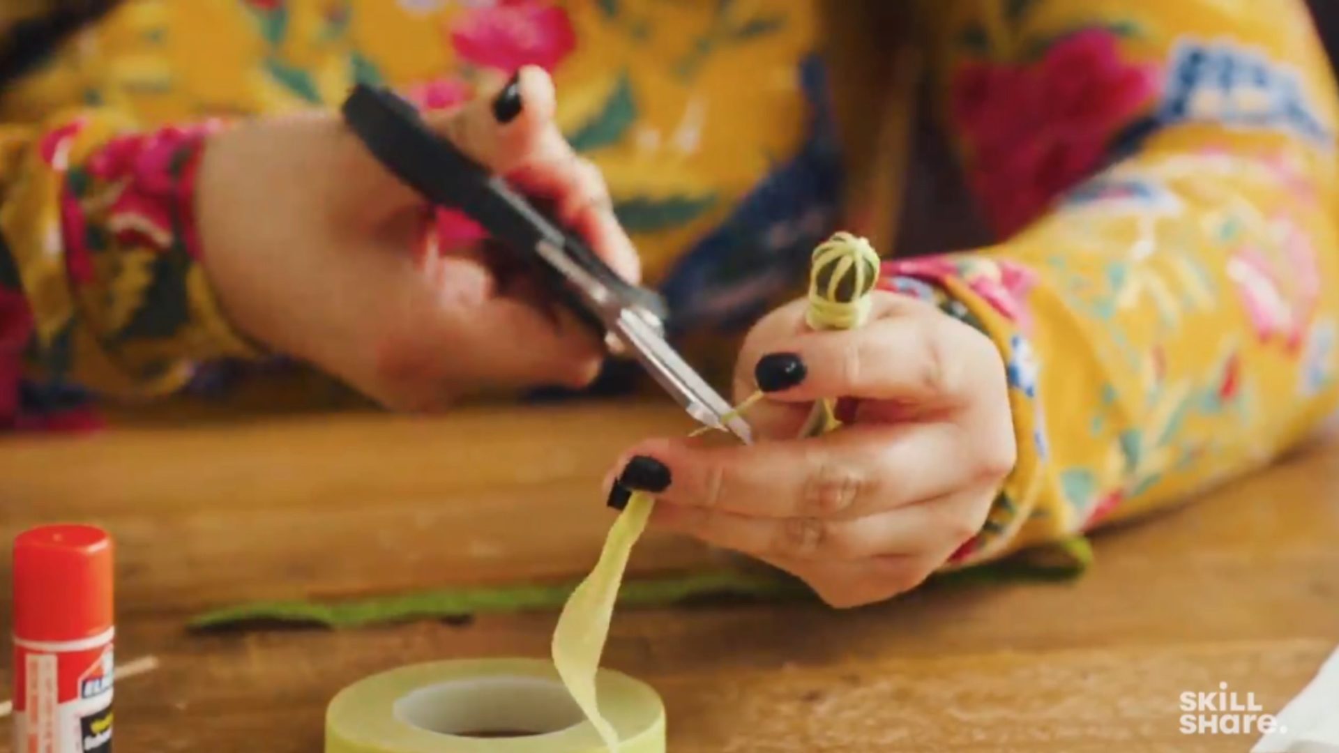 Person cutting floral tape from a cotton bud.