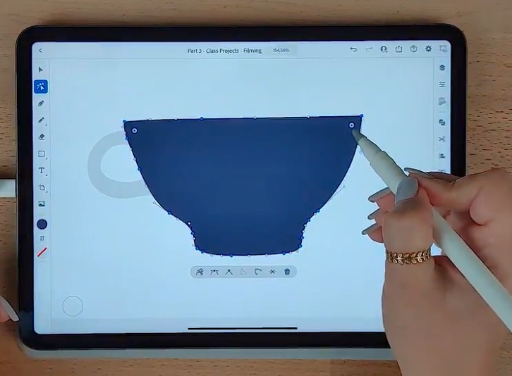 A blue teacup is made into a vector image using Adobe Illustrator on an iPad.