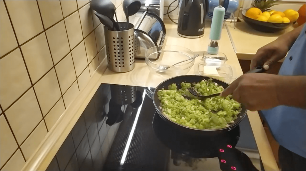 Someone sautees a mixture of celery, onion, and bell pepper on the stovetop.