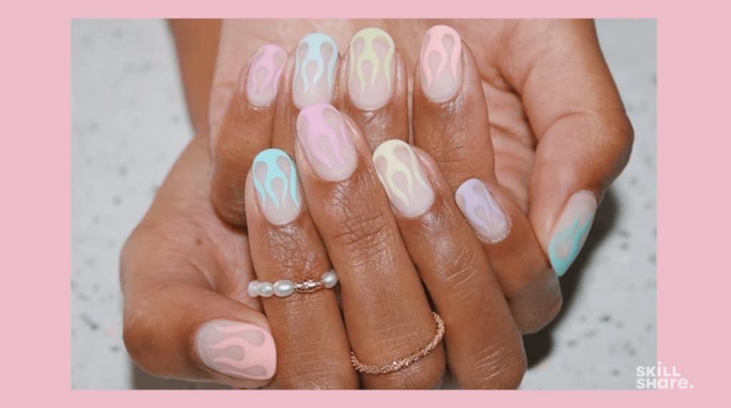 A pastel flame nail art design in pinks, blues, and yellows looks simple but requires hours of practice to perfect.