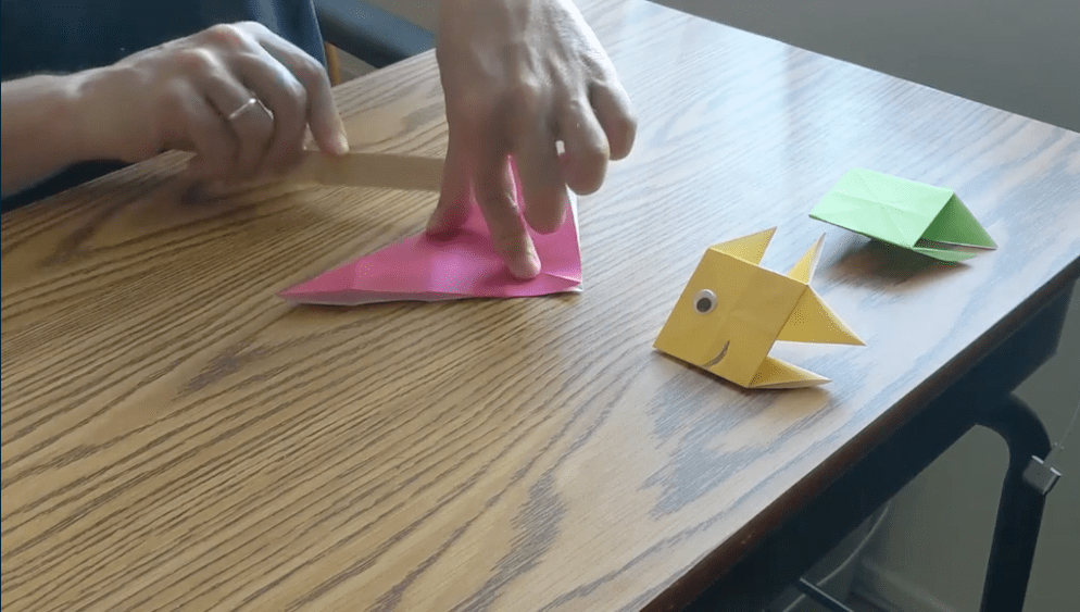 Folding origami paper into a triangle is an important step in making your paper fish.