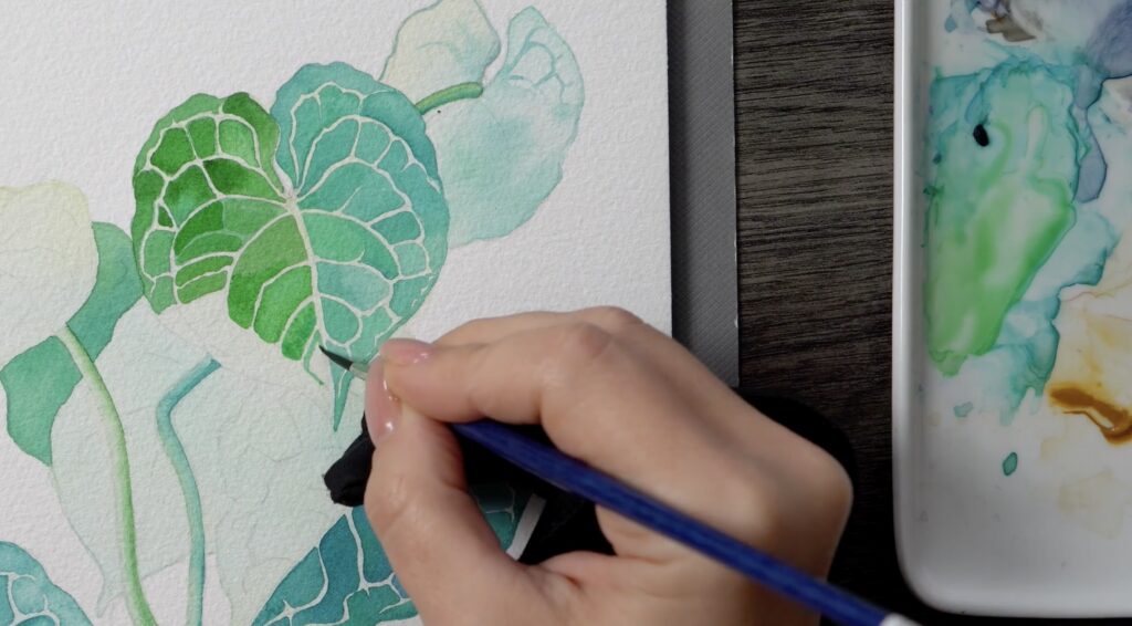 A watercolor painting of a blue and teal leaf. The veins and edges of the leaf are defined by unpainted, or negative, space.