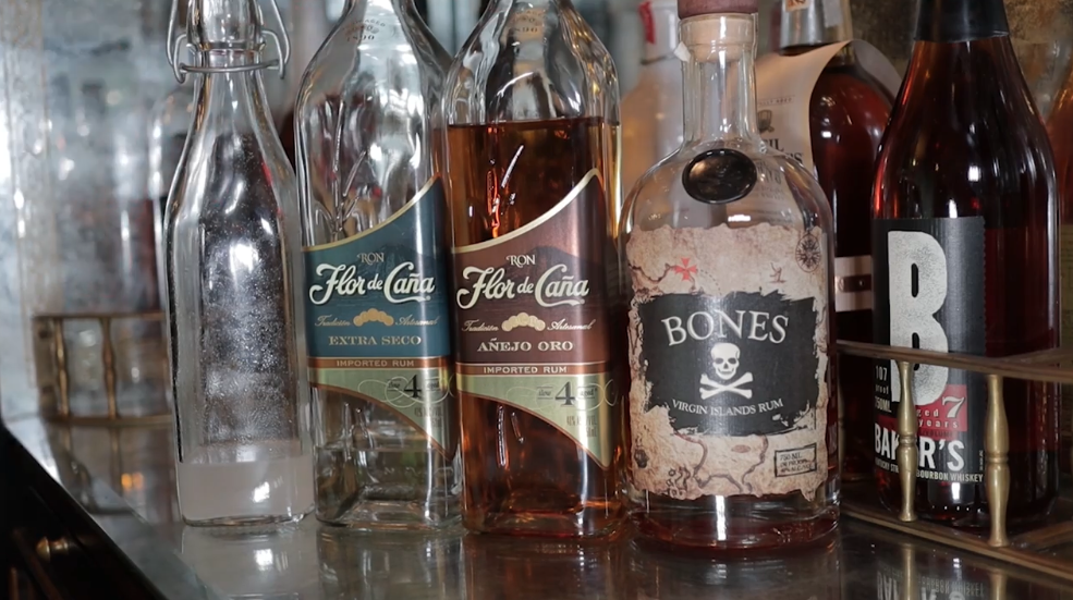 Three rum bottles of different varieties, waiting to be used in cocktails at a bar.