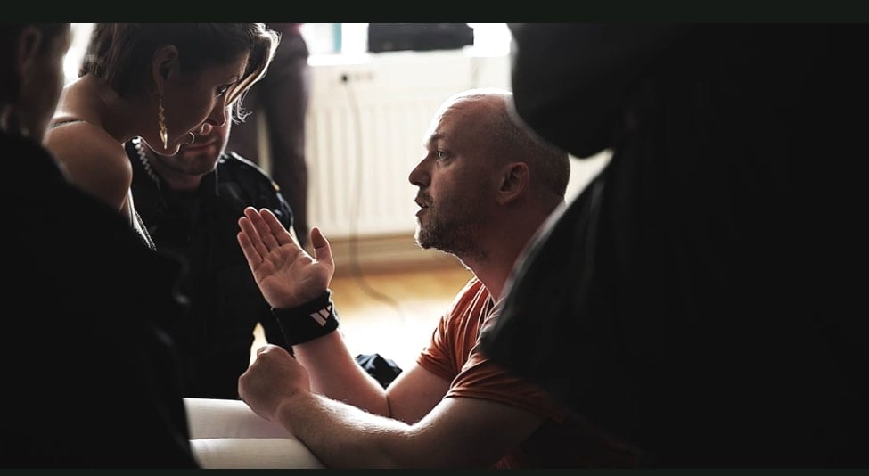 A film director gives instruction to actors while on set.