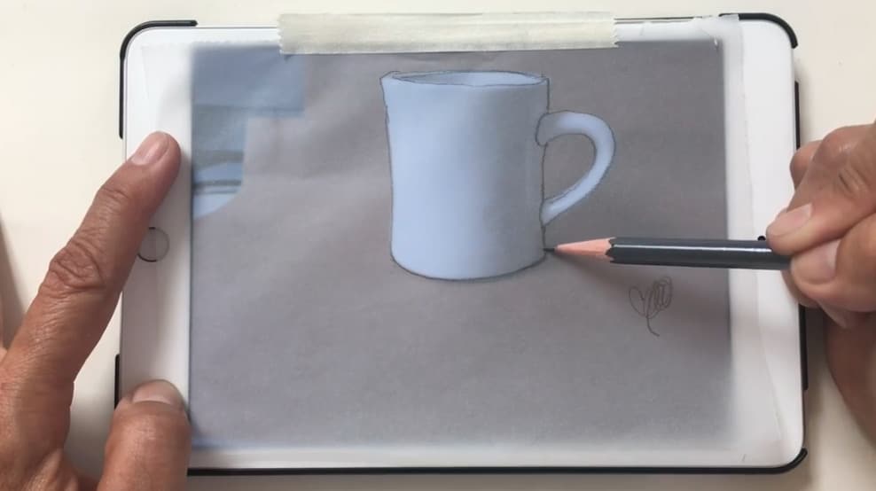 Tracing a picture of a mug on an iPad onto transfer or tracing paper.