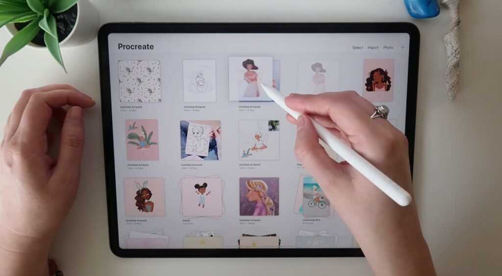 A Procreate canvas is being dragged and dropped onto another by an Apple Pencil. 