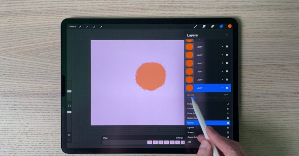 An iPad working in Procreate, adjusting the opacity of a circular, orange animation.   