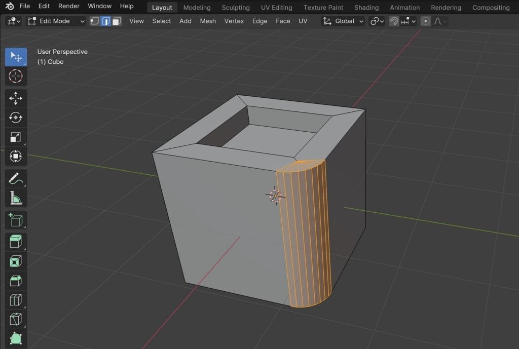 A cube rests in the middle of a Blender viewport. It has a square indent in its top face, and one of its front edges is rounded.