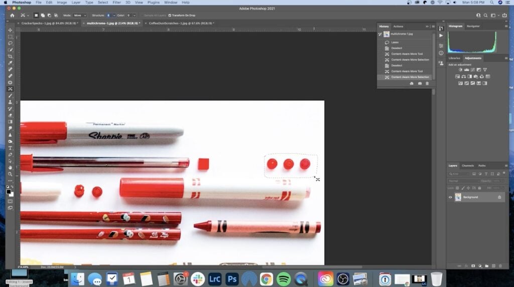 Adobe Photoshop is open to an image of red writing utensils lined up next to a few red legos. Three of the little red legos are selected and now moved to the right. 