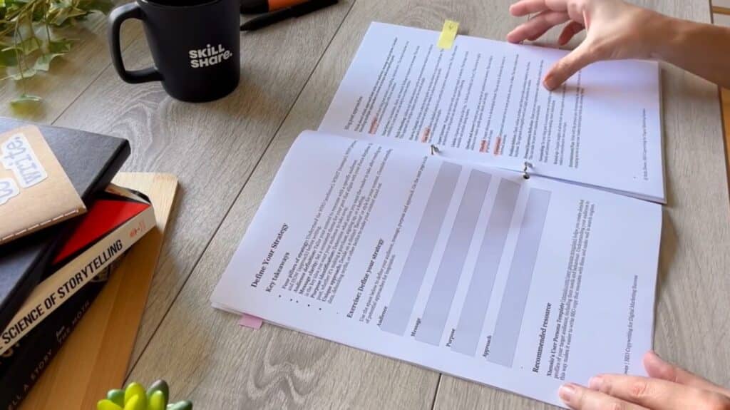A person’s hands touching a worksheet titled “Define Your Strategy” which is laying on a wooden tabletop.