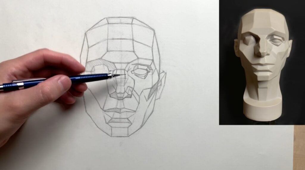 A person’s hand using a pencil to sketch a human head composed of many flat planes. The reference photo of the Asaro head is visible to the right of the drawing.