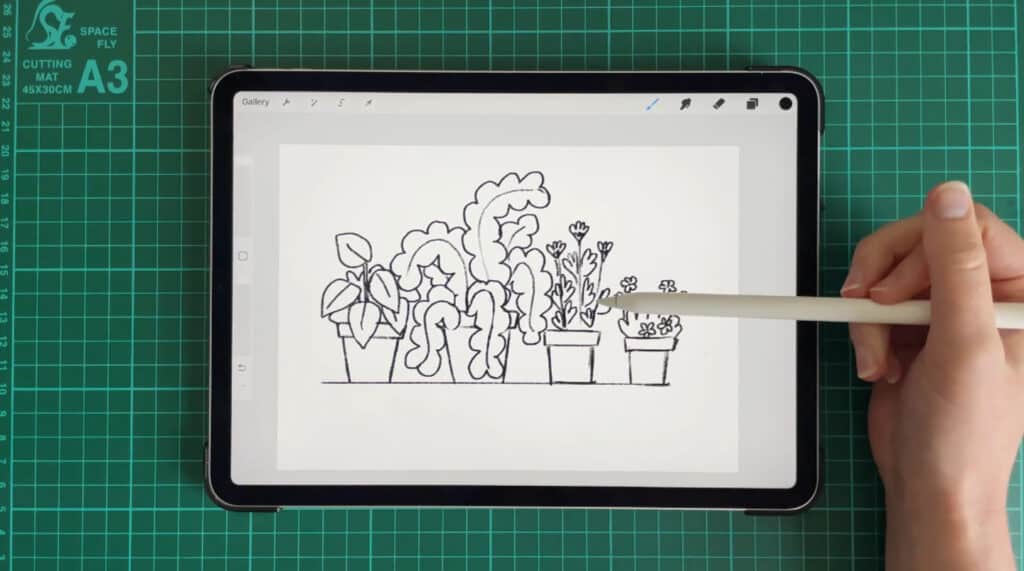 A person’s hand using an Apple Pencil to draw basic potted plants on an iPad.