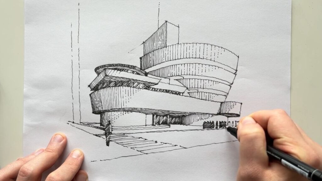 A person using a pen to create a drawing of New York City’s Guggenheim Museum on white paper. 