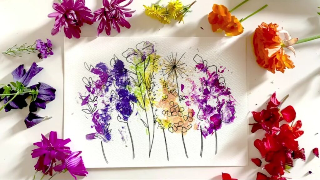 Overhead view of a floral print featuring hand-drawn flowers and bright color from the flowers themselves, surrounded by fresh flowers in red, orange, yellow, blue and purple