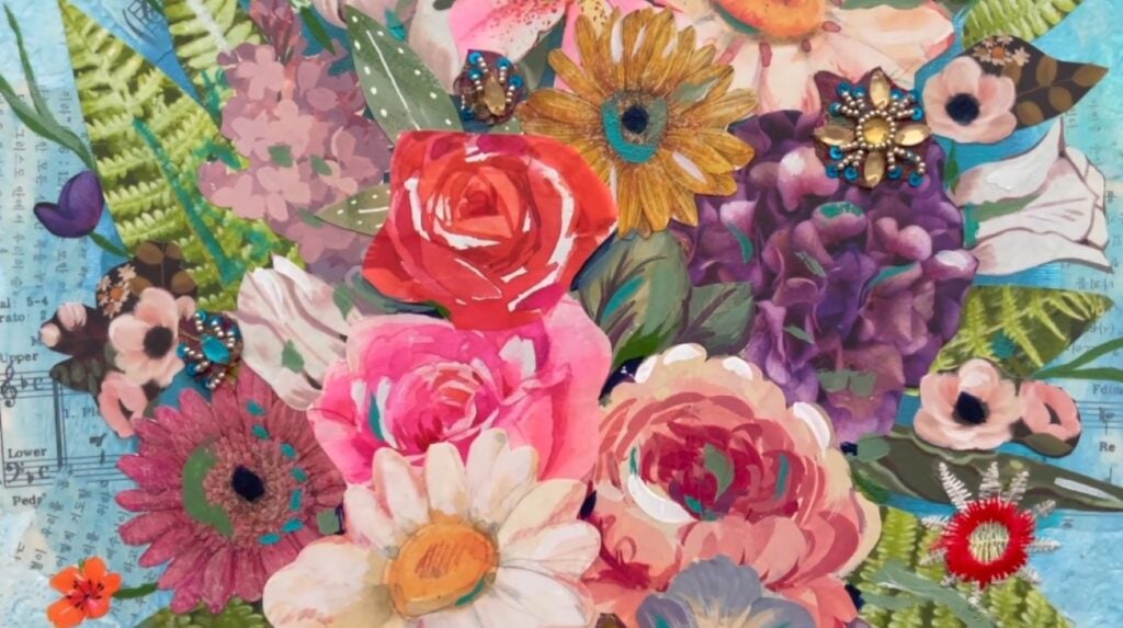 A mixed media flower bouquet against a blue background. Each flower is made from a cut-out piece of paper that’s been painted.