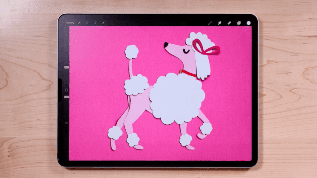 An iPad sits on a table open to a Procreate canvas that features an illustration of a paper cut-out-inspired pink poodle.