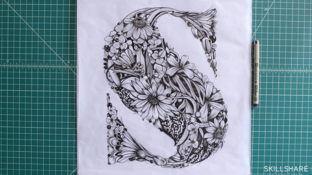 Large, pencil drawing of the letter S, and the entire letter is made of floral blooms and leaves against a green grid drawing surface