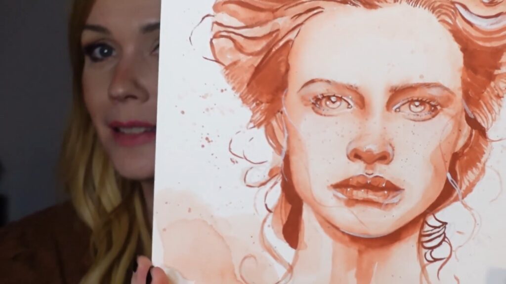 Artist holding a red-orange monochromatic portrait of a woman’s face up to the camera