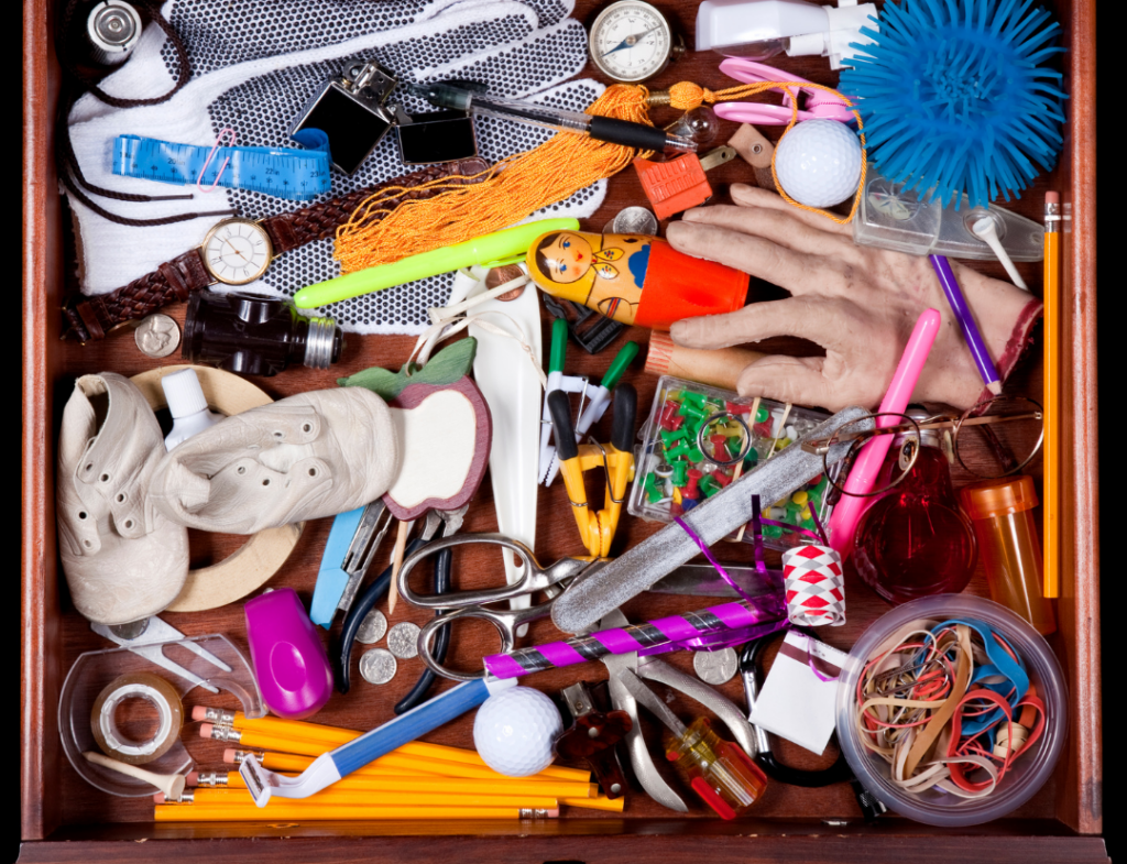 aerial view of a desk drawer filled with a mess of pens and other objects